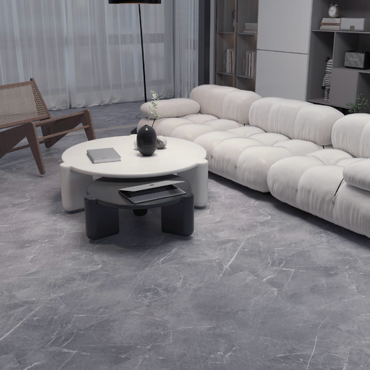Modern living room with a white sectional sofa, round coffee table, and decorative items.