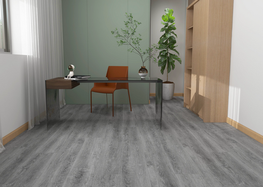 Modern office interior with a desk, chair, and plants on a gray wooden floor.